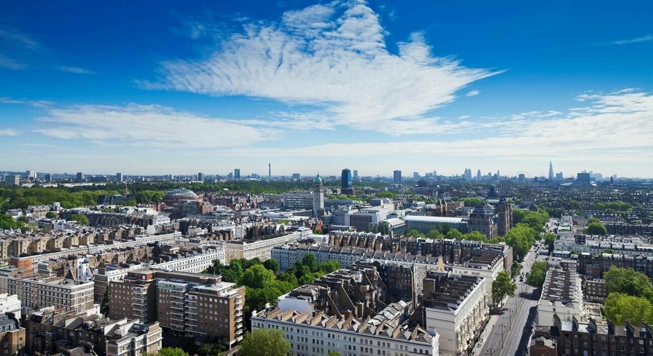 View from the hotel's upper floors across South Kensington rooftops to the dome of the Royal Albert Hall and the towers of the Natural History Museum, with central London on the skyline